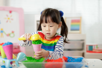 Cute girl playing with toy at home