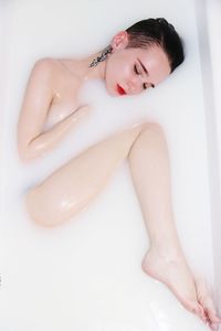 Directly above shot of sensuous woman with eyes closed in bathtub