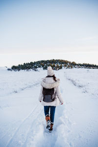 Back view of backpacker woman hiking in snowy mountain. winter season. nature