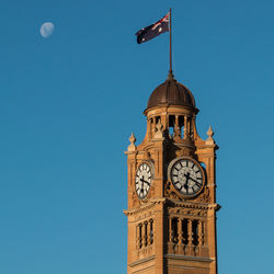 Low angle view of clock tower against blue sky