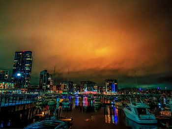 Illuminated buildings in city against sky at night