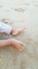 Low section of child on sand at beach