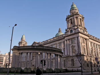 Man standing by historic building against sky