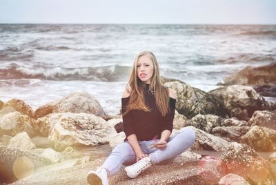 Young woman on rock at beach