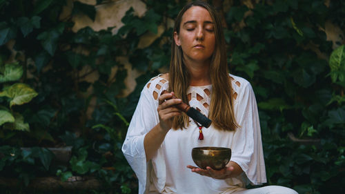 Portrait of young woman drinking water