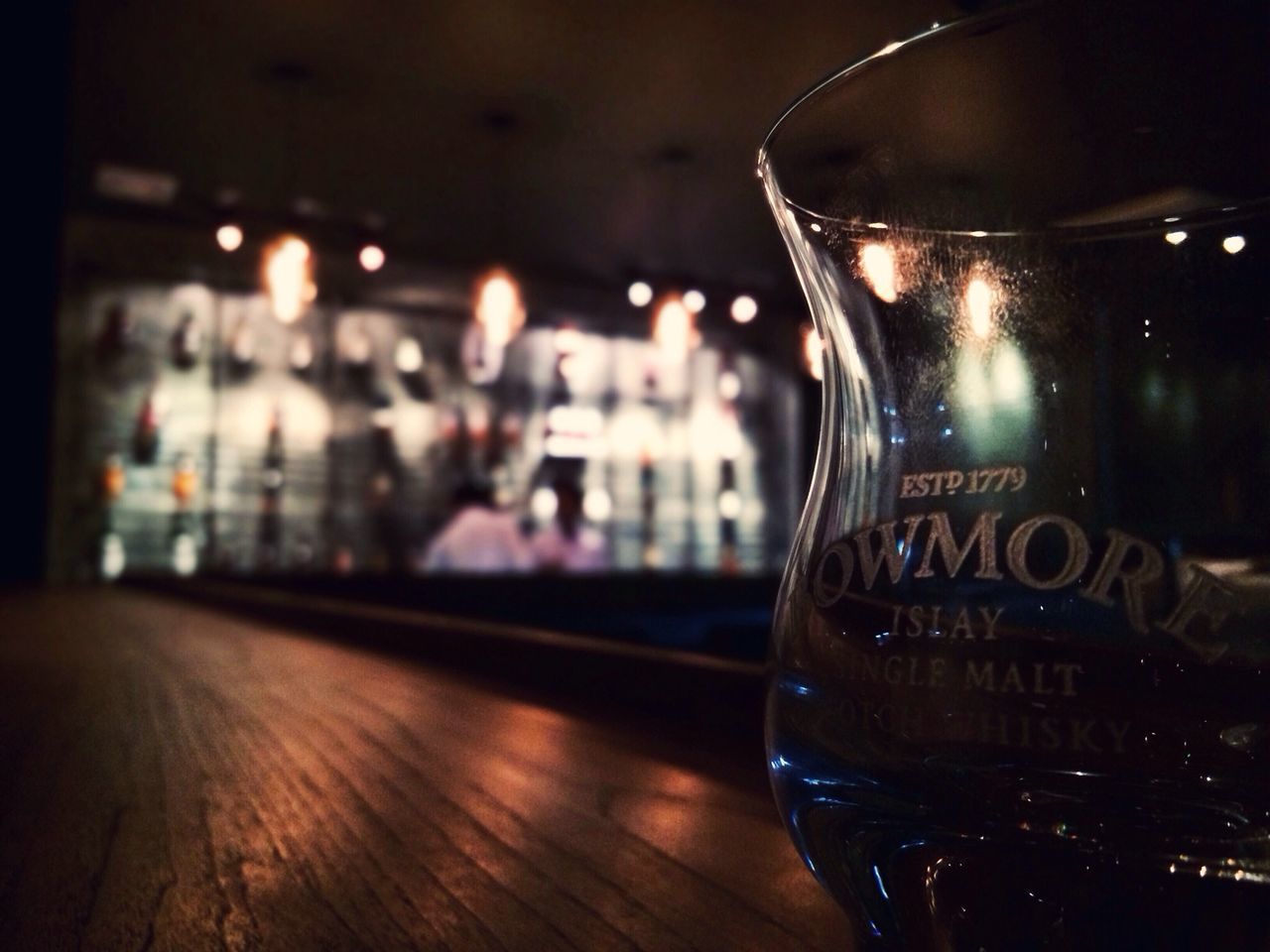 indoors, illuminated, focus on foreground, night, glass - material, close-up, transparent, table, text, selective focus, drink, restaurant, no people, western script, still life, drinking glass, alcohol, reflection, incidental people, food and drink