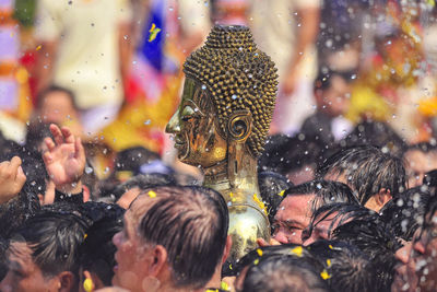 People carrying buddha statue during traditional ceremony