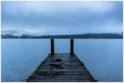 Pier over lake against sky