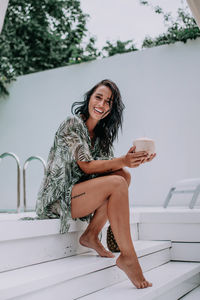 Portrait of a smiling young woman sitting outdoors