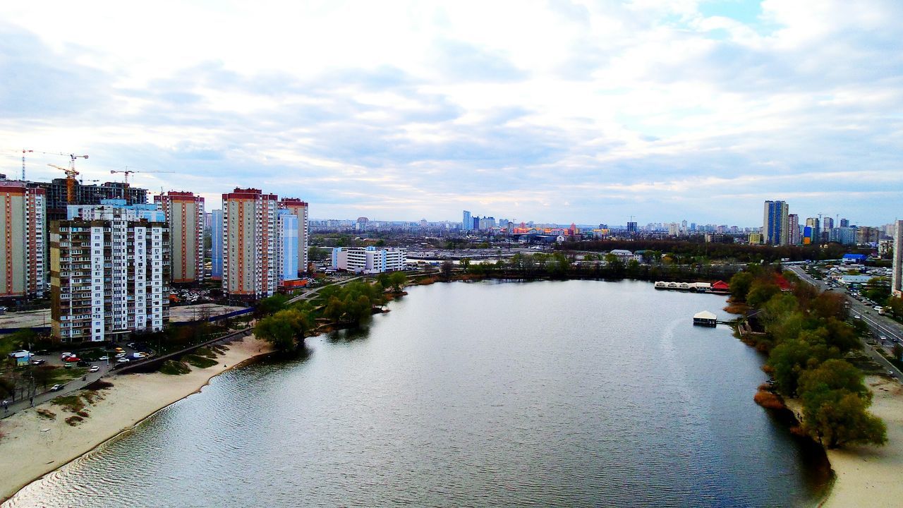 architecture, built structure, building exterior, water, sky, city, river, transportation, cloud - sky, waterfront, cityscape, connection, cloudy, high angle view, bridge - man made structure, day, cloud, outdoors, tree, city life