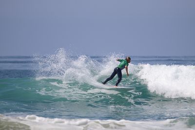 Man surfing in sea against clear sky