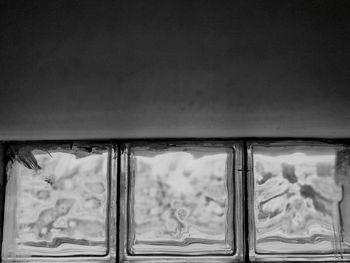 Close-up of glass window against sky