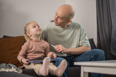 Side view of family sitting on sofa at home