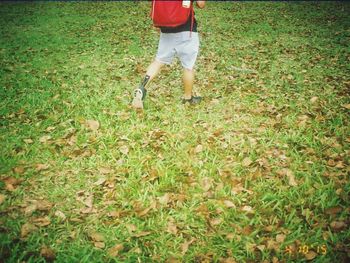 Low section of man standing on grassy field