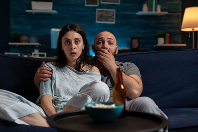 Man and woman sitting on sofa at home