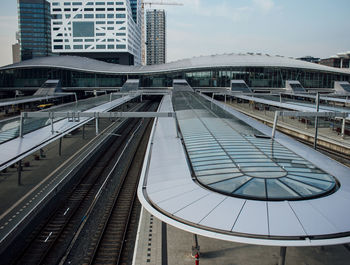 Railroad tracks amidst buildings in city against sky