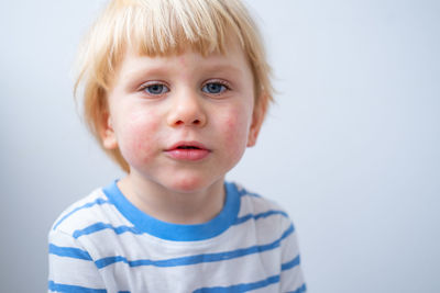 Close-up portrait of boy against white background