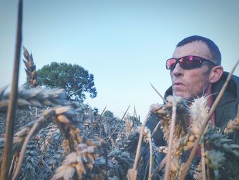 Portrait of man wearing sunglasses on field against sky