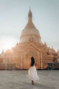 Rear view of woman looking at temple against sky