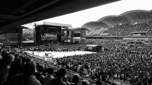 Crowd at music concert against sky