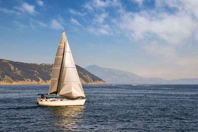 Sailboat at sea in the gulf of poets with the coastline in the background in summer