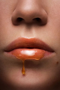 Cropped lips of woman with honey