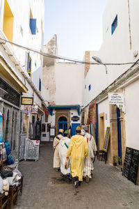 Rear view of people against buildings in city