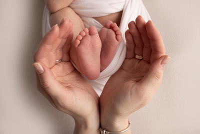 Cropped hand of woman holding baby
