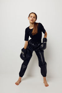 Portrait of young woman exercising against white background