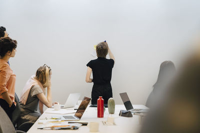 Colleagues in board room with transgender businessman planning strategy