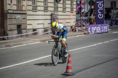 People riding bicycle on road in city