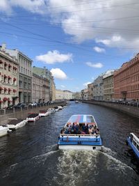 Boats in river against buildings in city