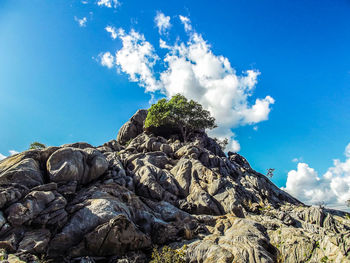 Low angle view of rocks against blue sky