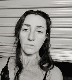 Close-up portrait of mature woman against shutter