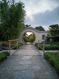 Footpath in park against sky