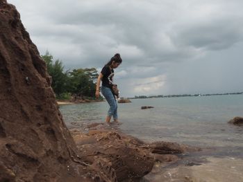 Side view of man on beach against sky