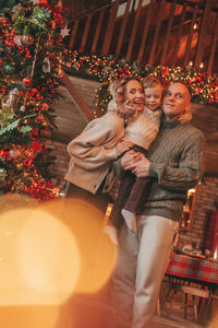 Candid authentic happy family during wintertime together enjoying holidays at wooden lodge at xmas