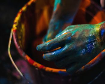 Cropped hands mixing paints in bucket