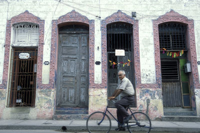 Full length of man riding bicycle on building