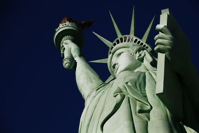 Low angle view of statue against blue sky