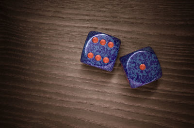 High angle view of purple dices on wooden table