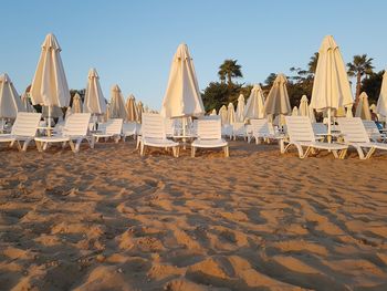 Panoramic view of parasols on beach against clear sky