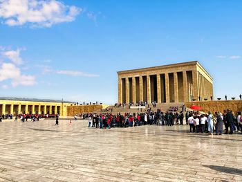 Group of people in front of built structure against sky