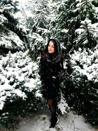 Young woman in snow covered tree