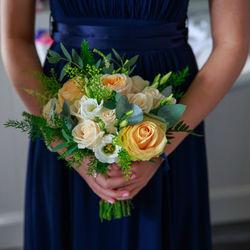 Midsection of woman holding rose bouquet