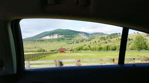 Scenic view of field seen through window