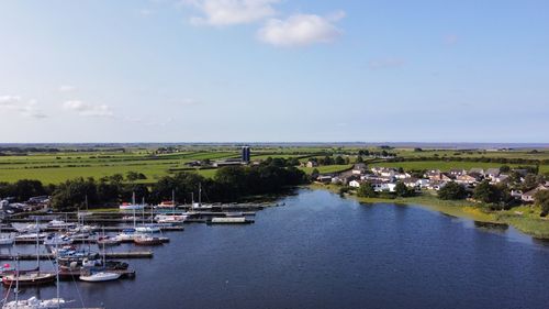 Sailboats moored on river against sky