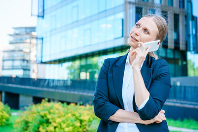 Business woman with phone near office. portrait beautiful smiling girl