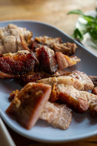 Close-up food photo of roasted pork meat on a white plate