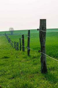 Wooden fence on field against sky